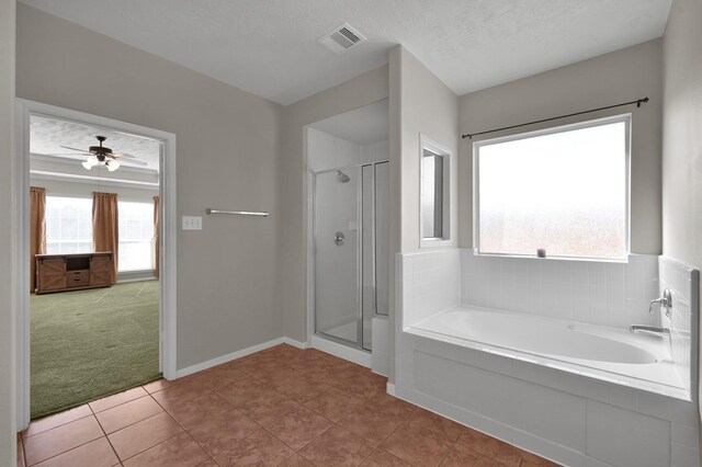 bathroom featuring visible vents, a textured ceiling, a shower stall, and a garden tub