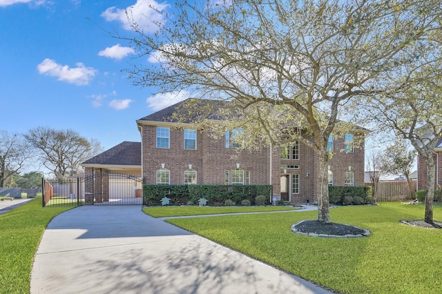 view of front of home with brick siding, a front lawn, fence, driveway, and a gate