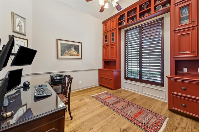 office space featuring a textured ceiling, lofted ceiling, light wood finished floors, and ceiling fan