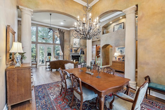 dining area featuring french doors, ornate columns, and wood finished floors