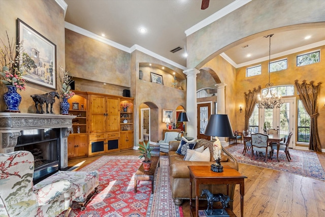 living room with visible vents, ornamental molding, hardwood / wood-style floors, arched walkways, and decorative columns