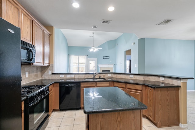 kitchen with black appliances, a center island, visible vents, and a sink