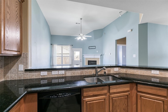 kitchen with brown cabinetry, a tile fireplace, black dishwasher, and a sink