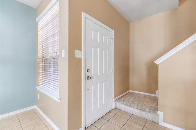 foyer featuring light tile patterned flooring and baseboards