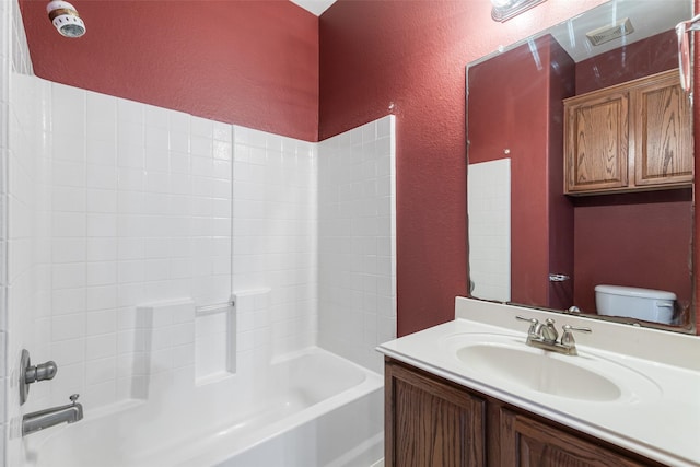 full bathroom featuring visible vents, toilet, shower / tub combination, vanity, and a textured wall