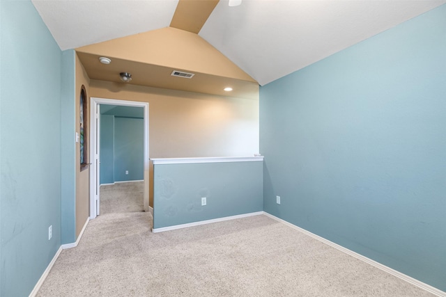 unfurnished room featuring visible vents, baseboards, carpet flooring, and vaulted ceiling