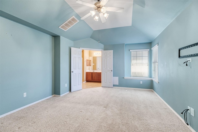 unfurnished bedroom featuring baseboards, visible vents, lofted ceiling, and light carpet