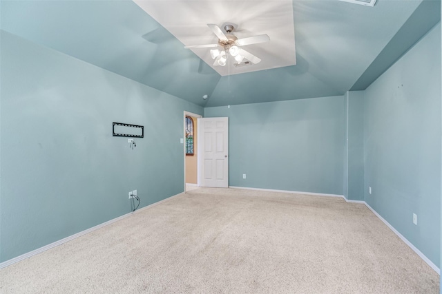 carpeted empty room featuring baseboards, lofted ceiling, and a ceiling fan