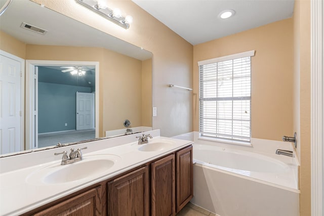 bathroom with double vanity, visible vents, a garden tub, and a sink