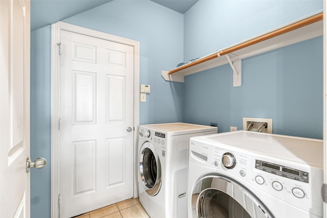 laundry room with washer and clothes dryer, laundry area, and light tile patterned floors