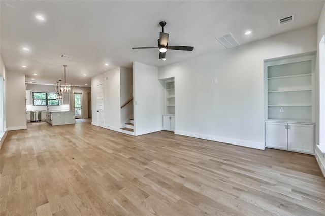 unfurnished living room featuring visible vents, baseboards, stairs, built in features, and light wood-type flooring