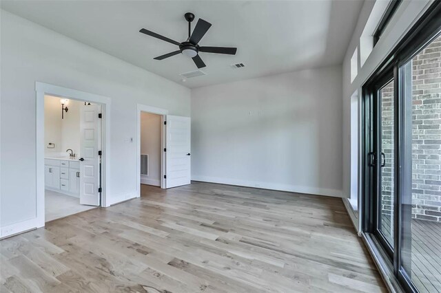 unfurnished bedroom featuring ensuite bathroom, visible vents, and light wood-style floors