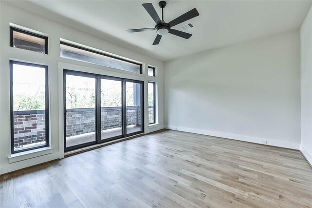 empty room with baseboards, visible vents, ceiling fan, and wood finished floors