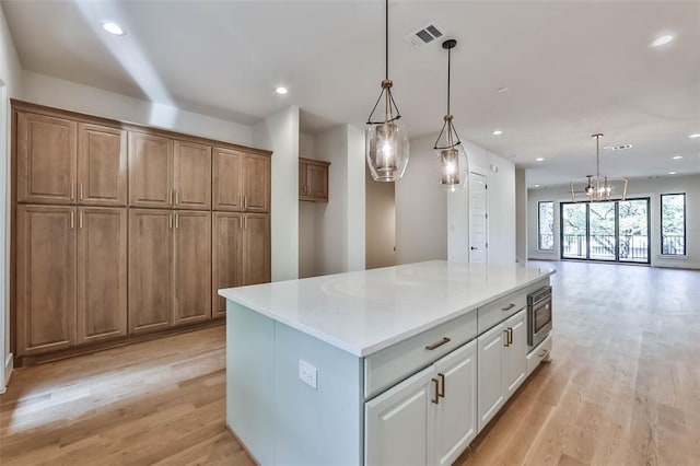 kitchen featuring light wood-type flooring, a center island, built in microwave, and recessed lighting