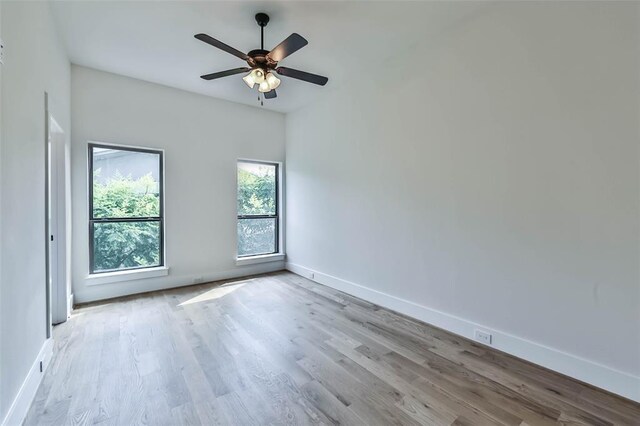 empty room featuring ceiling fan, baseboards, and wood finished floors