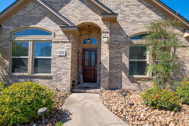 entrance to property featuring brick siding