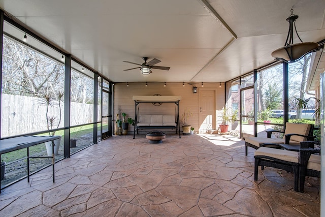 sunroom / solarium featuring a healthy amount of sunlight and a ceiling fan