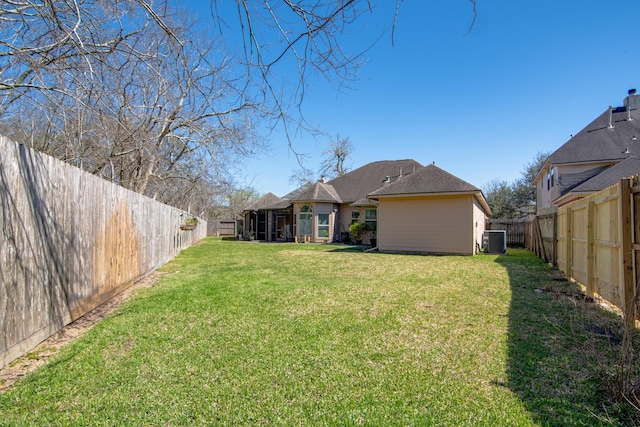 view of yard with central AC unit and a fenced backyard