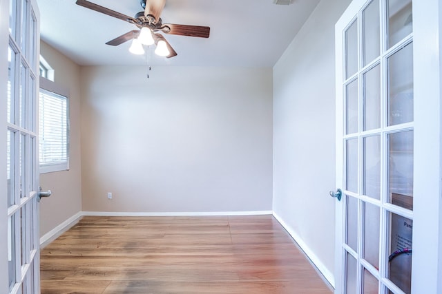 unfurnished room featuring a ceiling fan, visible vents, baseboards, light wood-style flooring, and french doors