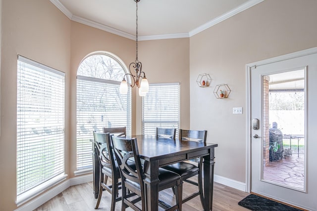 dining room featuring baseboards, light wood-type flooring, and ornamental molding