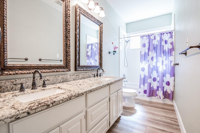 bathroom featuring a sink, shower / bath combo, wood finished floors, and double vanity