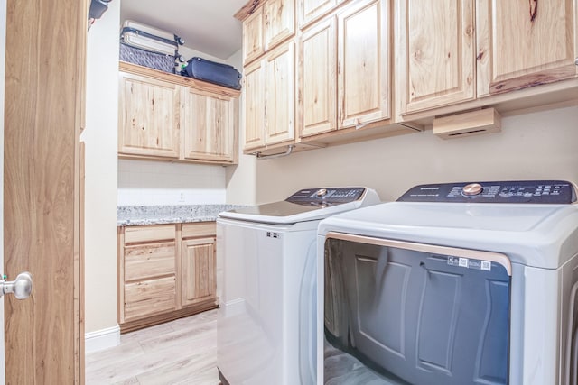 washroom with cabinet space, independent washer and dryer, and light wood-style flooring