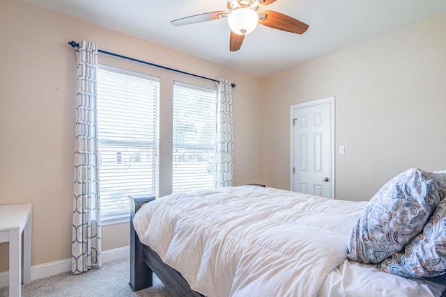 carpeted bedroom with baseboards, multiple windows, and a ceiling fan