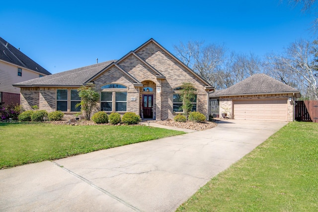 view of front of property with a front lawn, fence, roof with shingles, a garage, and brick siding