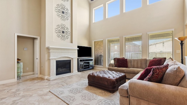 living area featuring a premium fireplace, baseboards, and marble finish floor