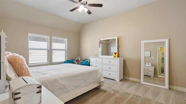 bedroom with light carpet, ceiling fan, baseboards, and vaulted ceiling