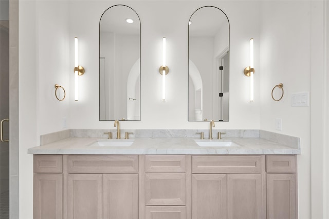 full bathroom with double vanity, a sink, and a shower with shower door