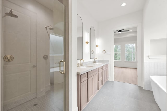 full bath featuring a freestanding bath, double vanity, a stall shower, and a sink