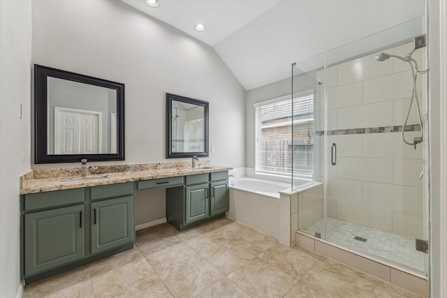 full bathroom featuring a stall shower, lofted ceiling, a sink, and a bath