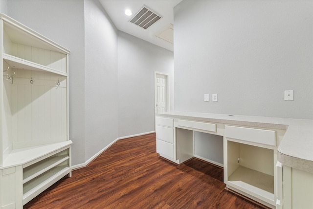 mudroom featuring baseboards, visible vents, dark wood finished floors, and built in desk