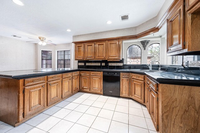 kitchen with dark countertops, visible vents, brown cabinetry, a sink, and a peninsula