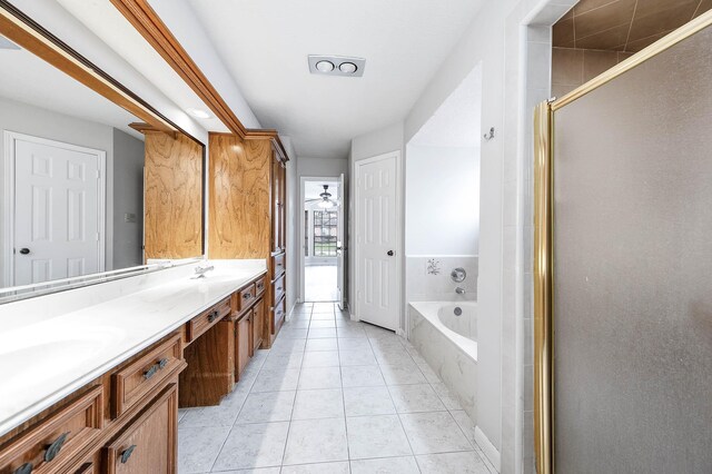 bathroom featuring double vanity, a sink, a shower stall, tile patterned flooring, and a bath