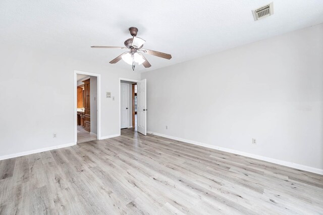 unfurnished room with visible vents, ceiling fan, baseboards, and wood finished floors