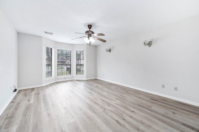 unfurnished room with visible vents, baseboards, and wood finished floors