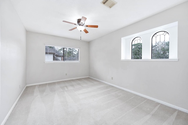 empty room featuring baseboards, ceiling fan, visible vents, and carpet flooring