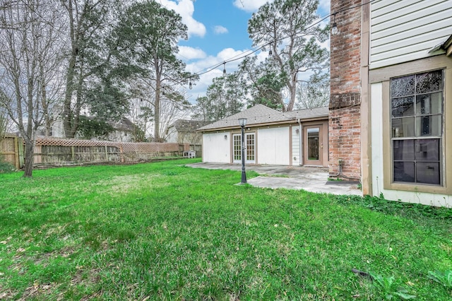 view of yard with french doors, a patio area, and fence