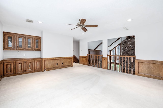 carpeted spare room featuring recessed lighting, visible vents, a ceiling fan, and wainscoting