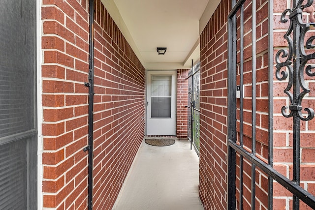 view of exterior entry featuring brick siding