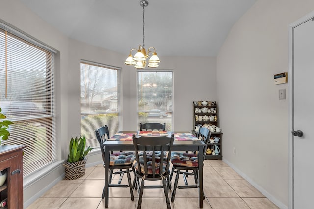 dining area with a chandelier, light tile patterned flooring, and baseboards