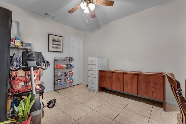 interior space featuring light tile patterned floors, baseboards, visible vents, and a ceiling fan