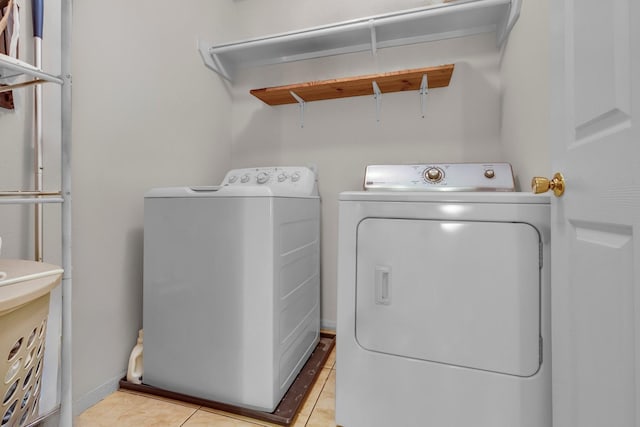 laundry area with laundry area, light tile patterned floors, attic access, baseboards, and washing machine and dryer