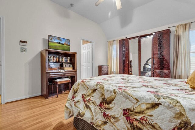 bedroom with ceiling fan, vaulted ceiling, baseboards, and wood finished floors