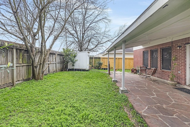 view of yard with a fenced backyard, an outdoor structure, and a patio