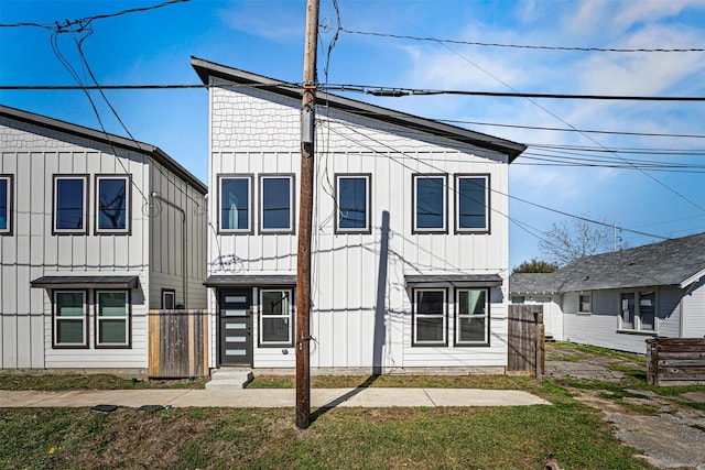 view of front of house with board and batten siding and fence