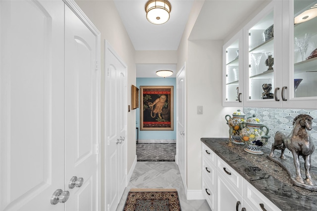 bar with baseboards, marble finish floor, and decorative backsplash