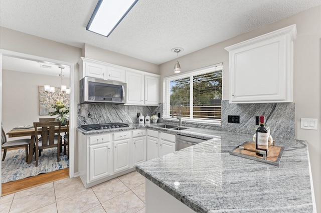 kitchen featuring light tile patterned flooring, white cabinetry, stainless steel appliances, and a sink